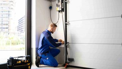 Homeowner placing wooden test block under garage door to test auto-reverse contact safety feature during monthly maintenance check