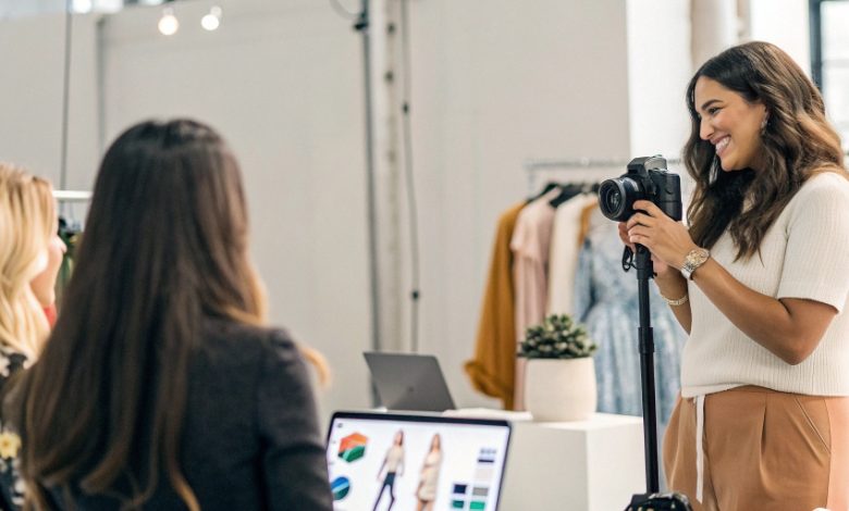 A young influencer recording content on a smartphone while surrounded by a ring light, laptop, and social media icons, representing creative ways to earn money online through influencing.