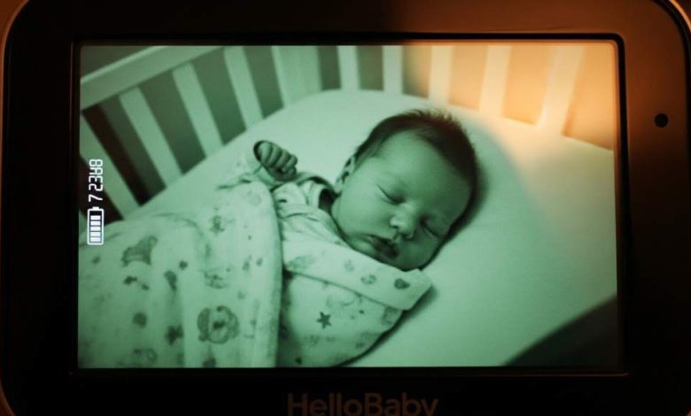 HelloBaby video baby monitor screen showing a sleeping infant in night vision mode