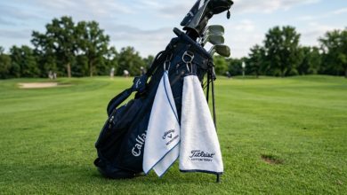 Side-by-side comparison of a microfiber golf towel and a cotton terry golf towel clipped to a golf bag on a green fairway