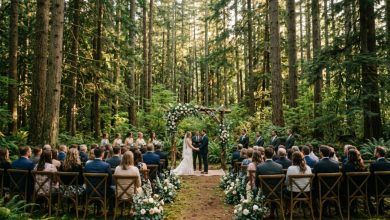 A rustic floral arch stands ready for a wedding ceremony in a Washington pine forest.