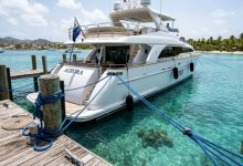 Yacht secured with blue nylon dock lines to a wooden dock.