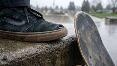 Skateboarder inspecting a worn toe on a skate shoe