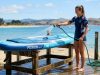 Vibrant inflatable paddle board resting on a sunny Florida beach near ocean waves