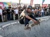 Young skater performing a trick on a concrete bowl during a skate park contest